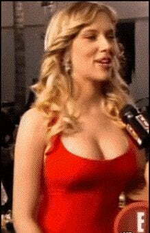 Scarlett Johansson smiling and letting a random reporter squeeze her bosom on camera